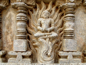 Représentation d'une pratique ascétique où le yogin apprend à maîtriser la chaleur, interne et externe. Il est dit que l'ascèse yogique peut générer d'intenses chaleurs (tapas). Paroie d'un temple du Karnataka | Source Karl-Stephan Bouthillette